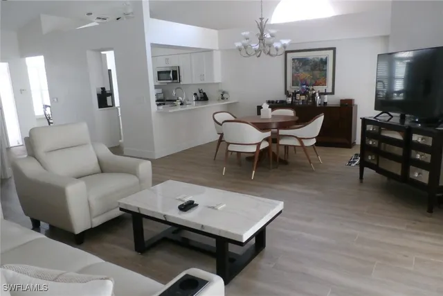 a living room with furniture a flat screen tv and kitchen view