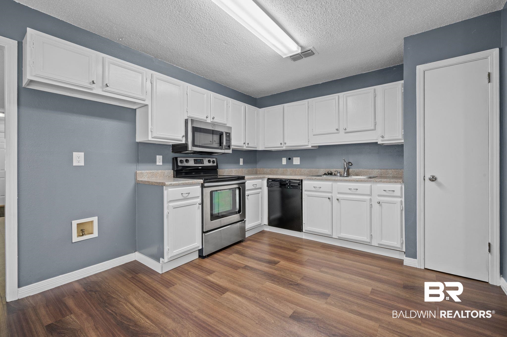 3716 Pepper Ridge Drive Mobile, AL 36693 - Photo 9 of 20 Kitchen with stainless steel appliances, a textured ceiling, white cabinets, and sink
