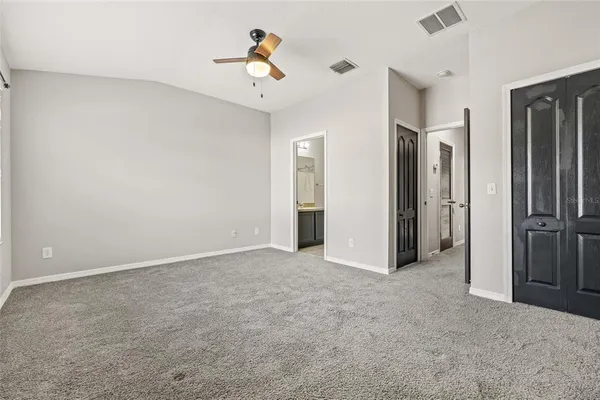 an empty room with chandelier fan