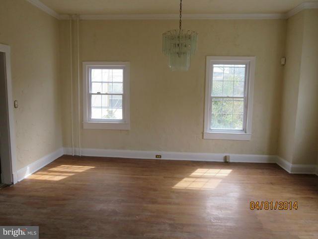 6220 Liberty Road Baltimore, MD 21207 - Photo 4 of 9 an empty room with wooden floor chandelier and windows
