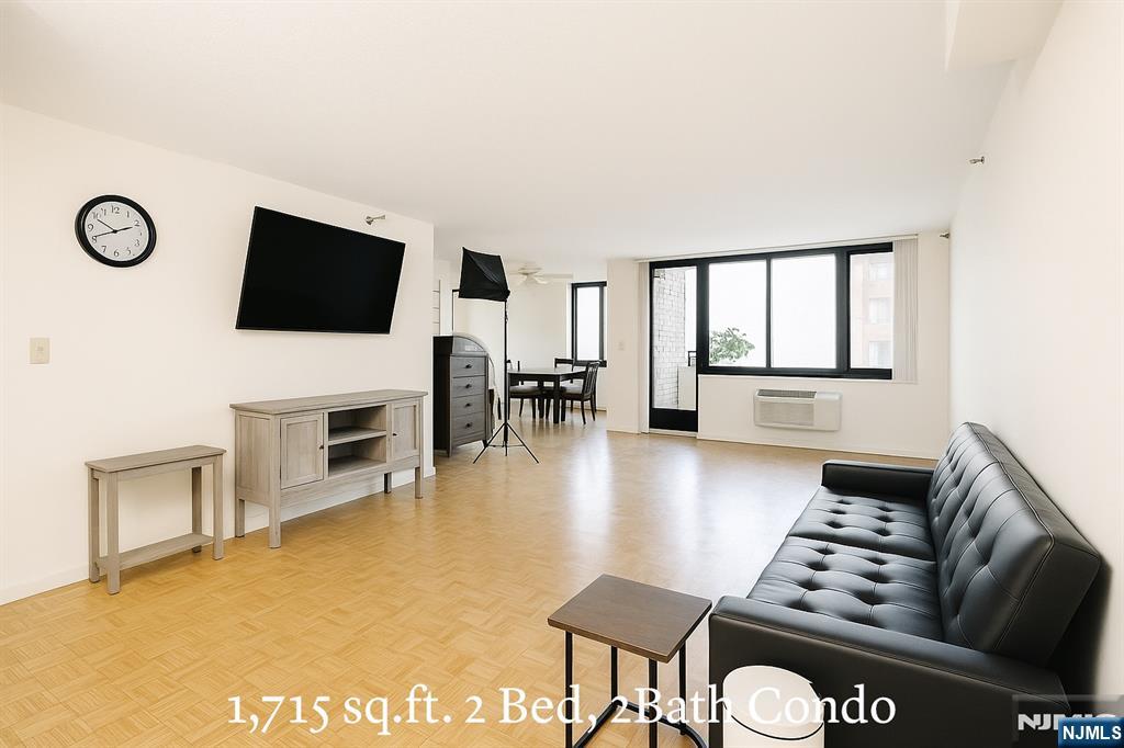 1265 15th Street, Unit 1A Fort Lee, NJ 07024 - Photo 5 of 14 a living room with furniture a fireplace and a flat screen tv