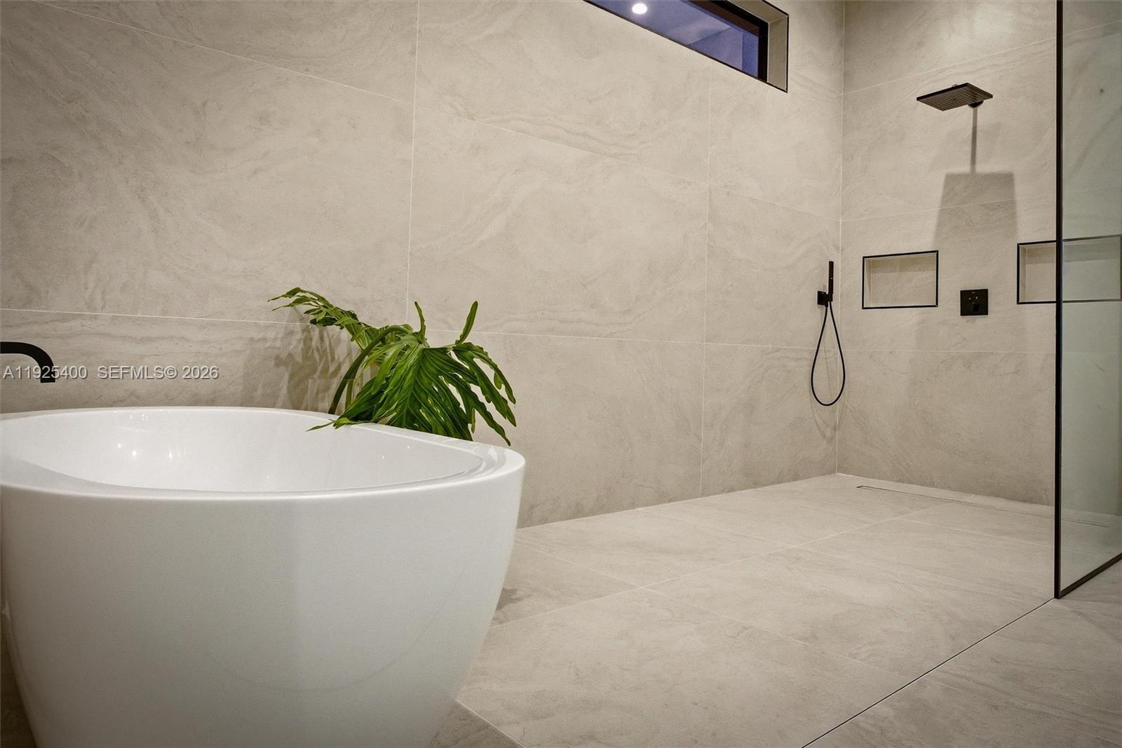 9840 Southwest 73rd Court Pinecrest, FL 33156 - Photo 41 of 67 Primary Bath | Soaking Tub & Rain Shower | Floor-to-Ceiling Tile | Spa Finishes