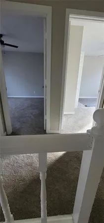 an empty room with a ceiling fan and windows