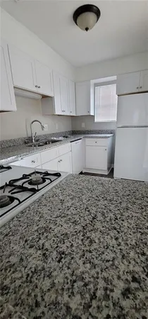 a kitchen with a stove a sink and cabinets