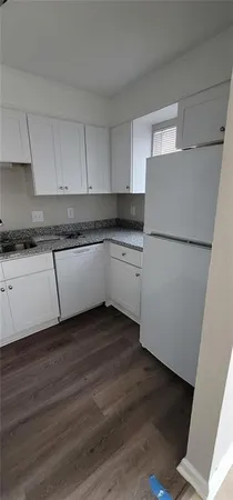 a kitchen with wooden cabinets and white appliances