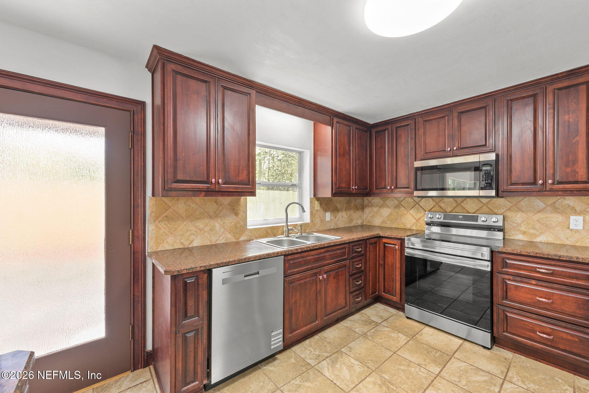 2003 Laurel Street Palatka, FL 32177 - Photo 11 of 31 a kitchen with stainless steel appliances granite countertop wooden cabinets a stove top oven a sink and dishwasher