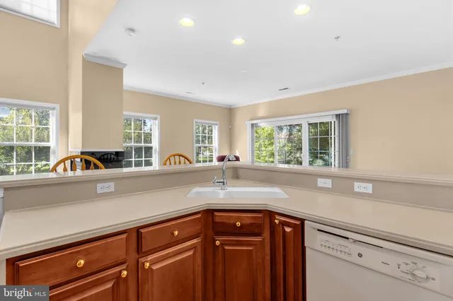 a kitchen with stainless steel appliances granite countertop a sink a window and cabinets