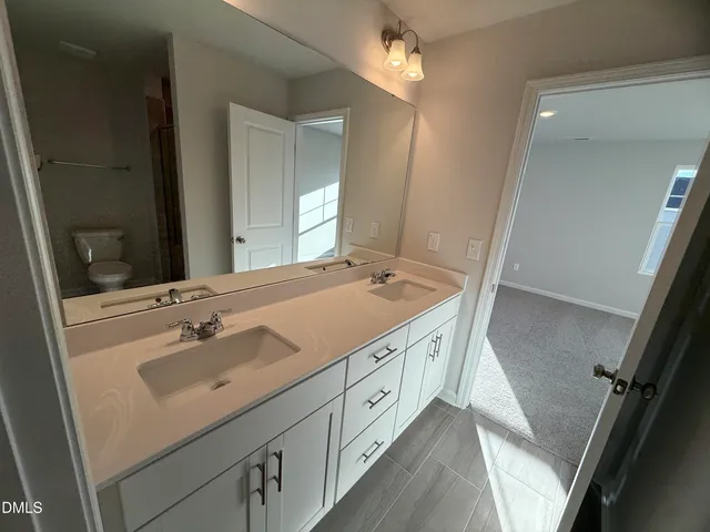 a spacious bathroom with a double vanity sink and mirror