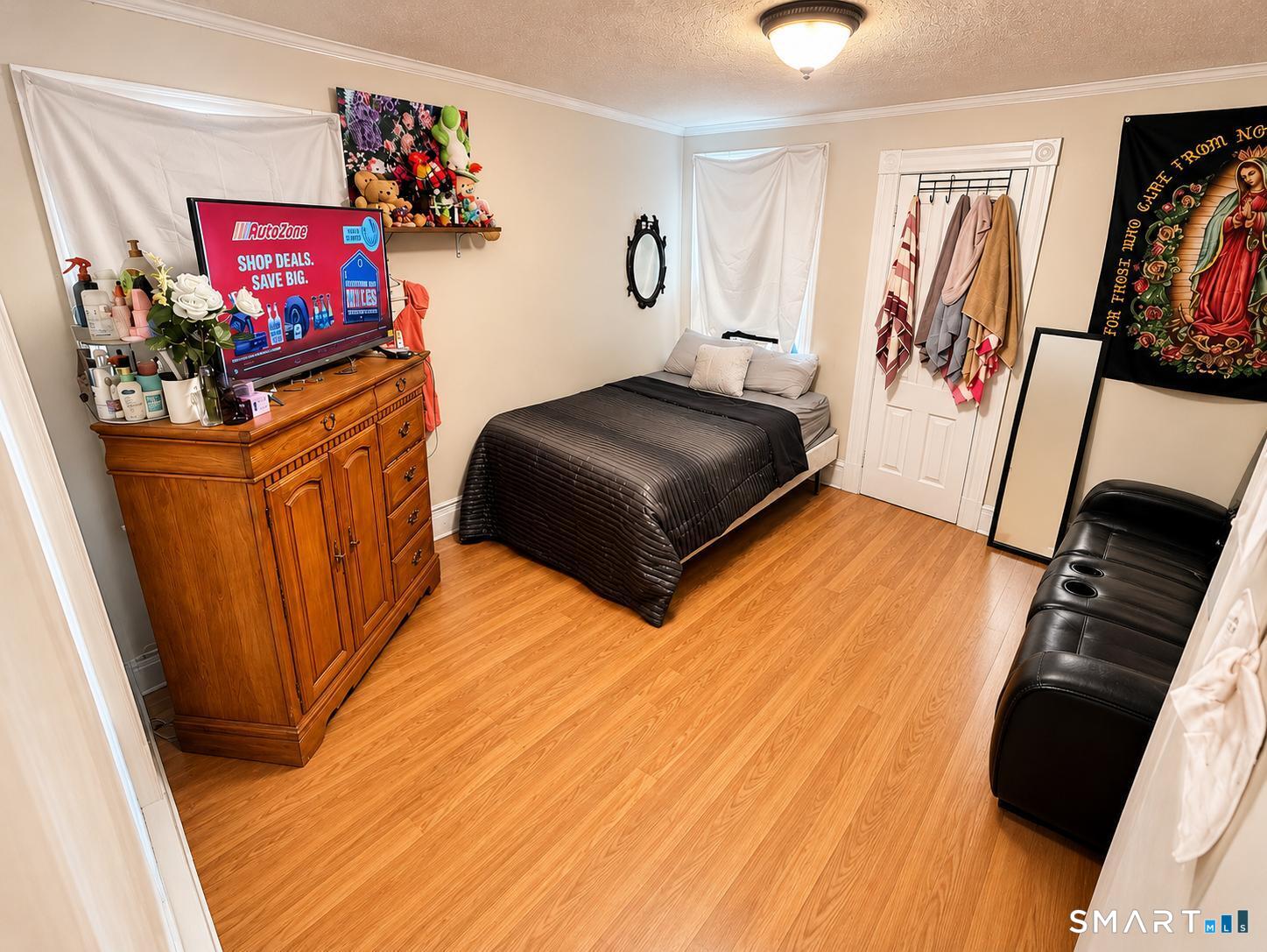 98 Huntington Road Bridgeport, CT 06608 - Photo 10 of 15 a bedroom with a bed and a flat tv screen on the dresser