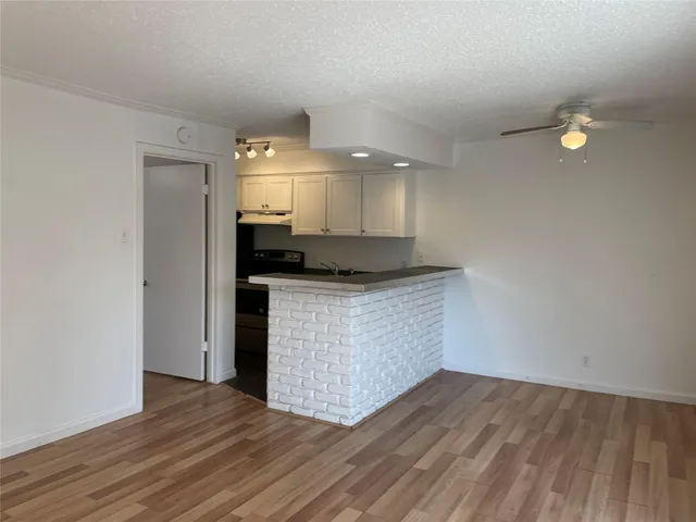 a view of kitchen cabinets and wooden floor