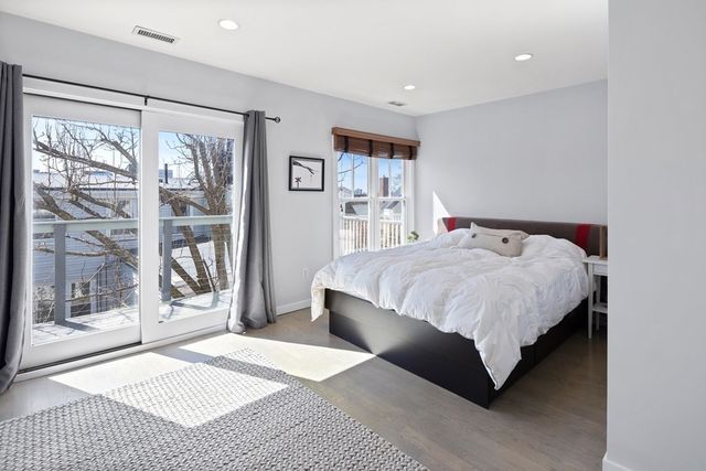 a bedroom with a bed lamp and large window