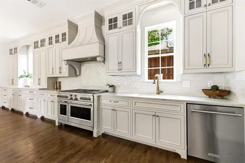 a kitchen with stainless steel appliances granite countertop a stove and white cabinets