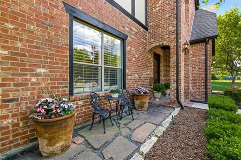 a view of a patio with couple of chairs and a fountain