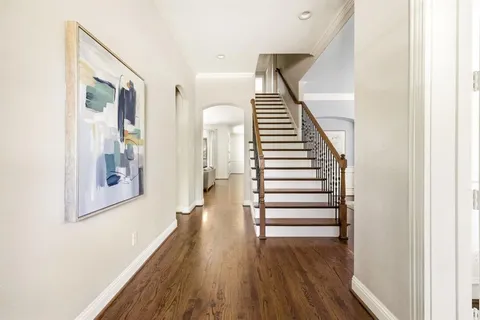 a view of a hallway with wooden floor and stairs