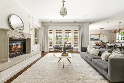 a living room with furniture a fireplace and a floor to ceiling window