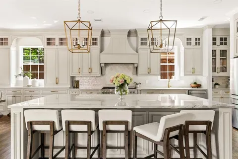 a kitchen with granite countertop white cabinets and chairs