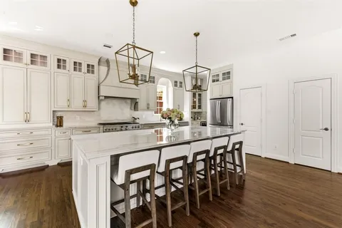 a kitchen with stainless steel appliances granite countertop a white cabinets and wooden floor