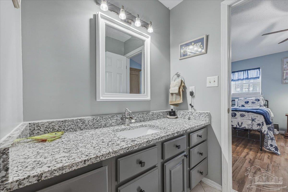 26063 Canal Road, Unit 3F Orange Beach, AL 36561 - Photo 61 of 72 a bathroom with a granite countertop sink and a mirror