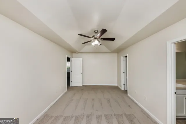 a view of an empty room with a ceiling fan