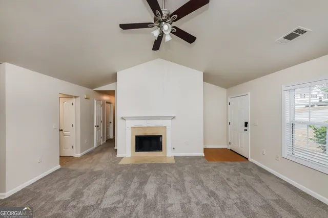 a view of a livingroom with a fireplace a ceiling fan and hardwood floor
