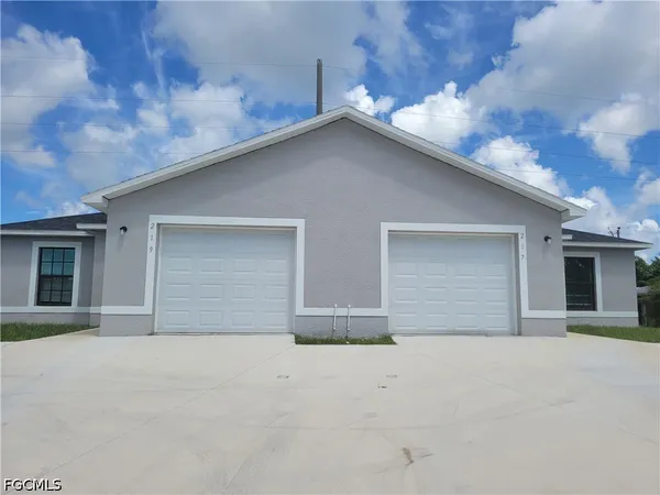 a view of house with garage and yard