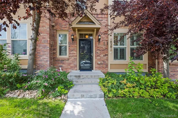 front view of a brick house with a small yard