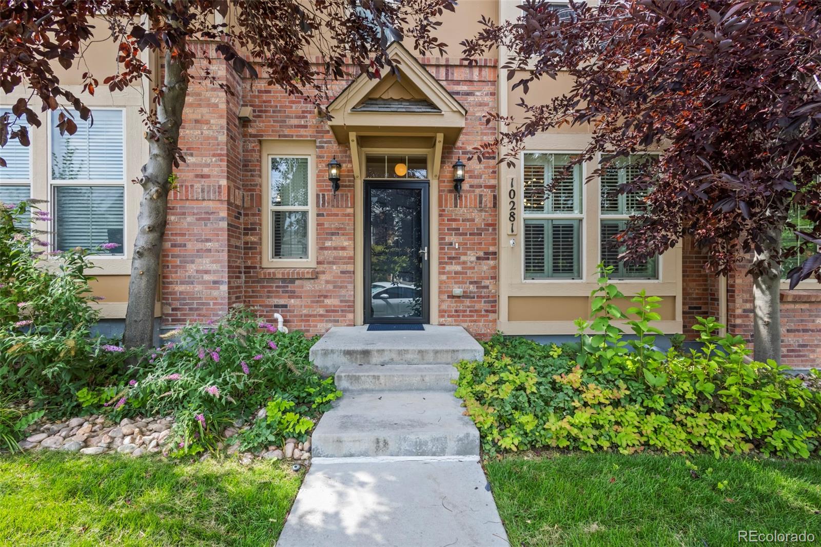 front view of a brick house with a small yard