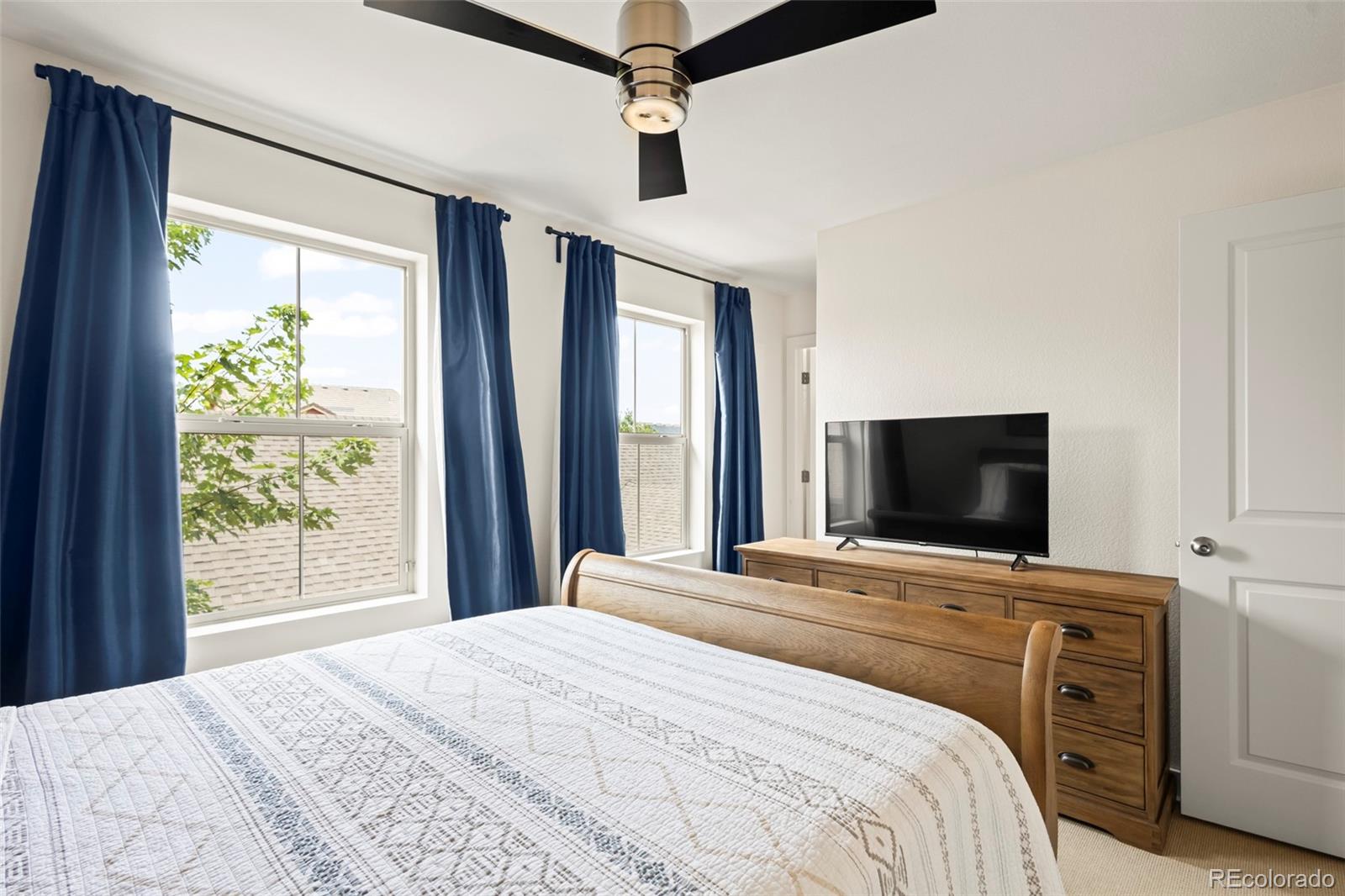10281 Bellwether Lane Lone Tree, CO 80124 - Photo 15 of 47 a bedroom with a bed and a flat screen tv