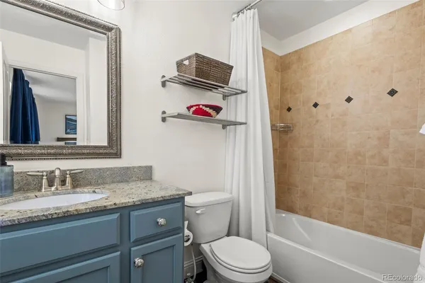 a bathroom with a granite countertop sink toilet and shower