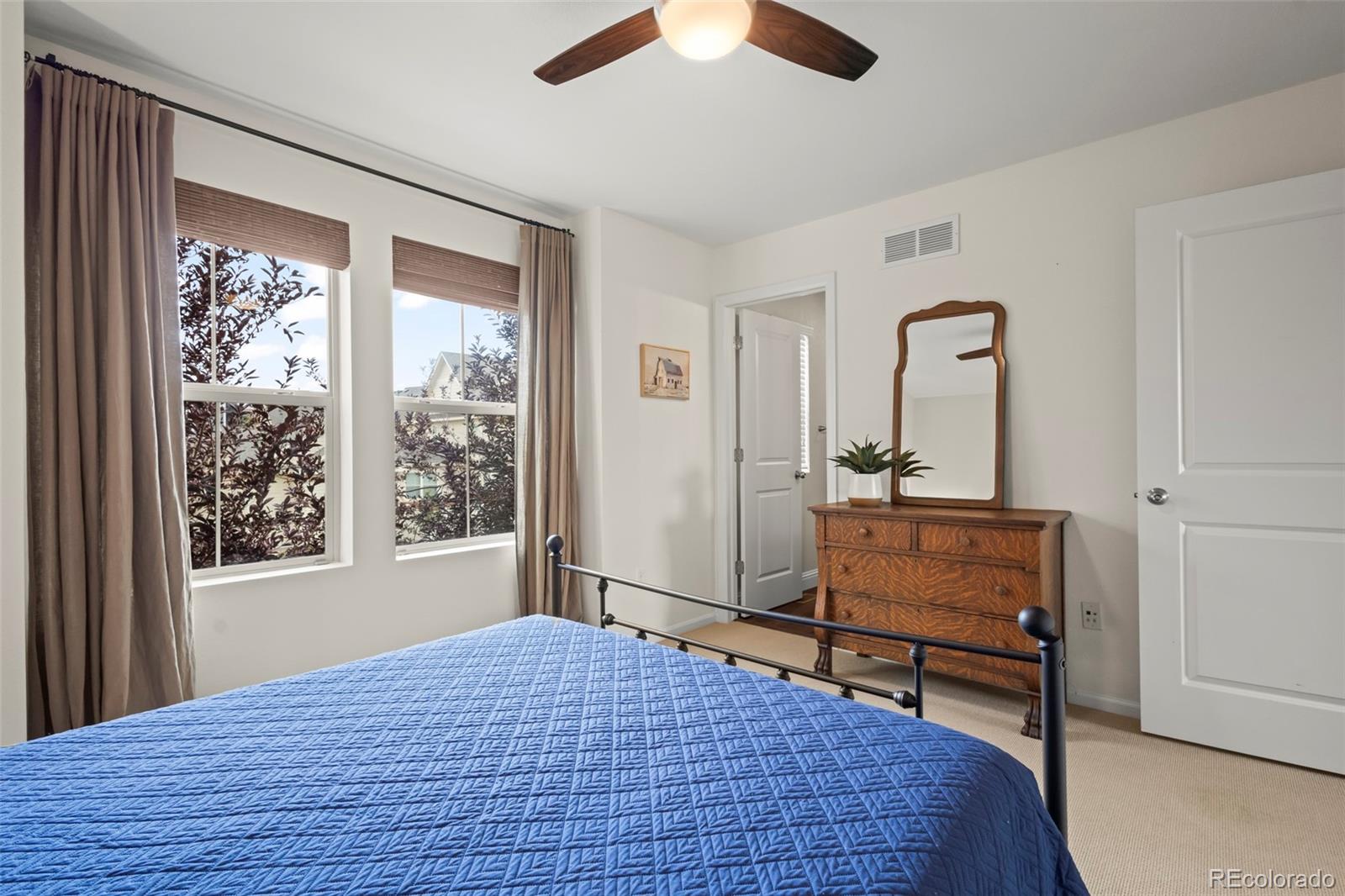 10281 Bellwether Lane Lone Tree, CO 80124 - Photo 19 of 47 a bedroom with a bed and a dresser next to a window