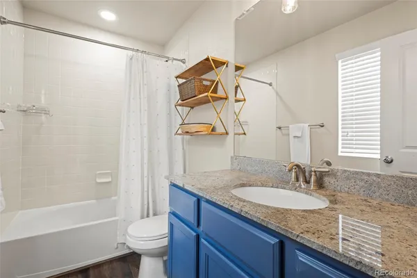 a bathroom with a granite countertop sink toilet and shower