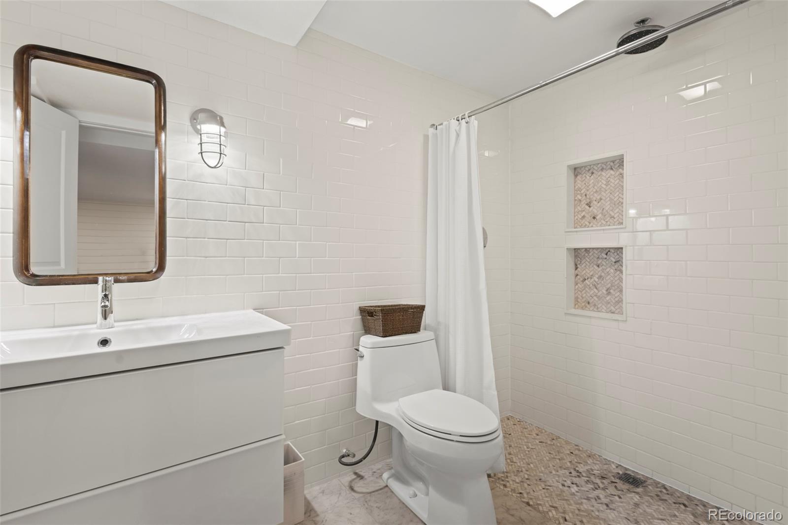 10281 Bellwether Lane Lone Tree, CO 80124 - Photo 26 of 47 a bathroom with a toilet a sink and mirror