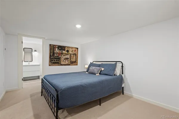 a bedroom with a bed and painting on the wall