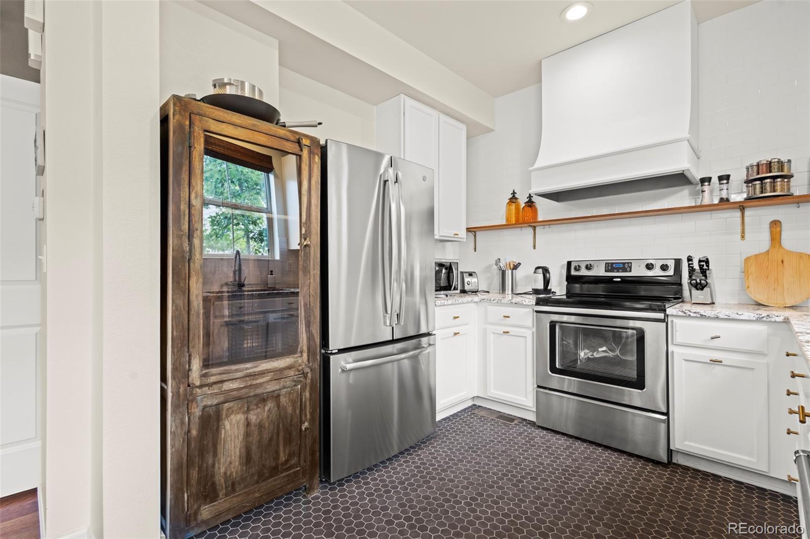 10281 Bellwether Lane Lone Tree, CO 80124 - Photo 29 of 47 a kitchen with a refrigerator and a stove top oven