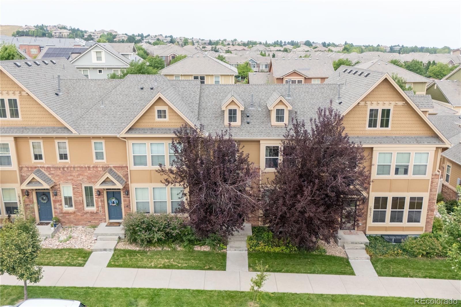 10281 Bellwether Lane Lone Tree, CO 80124 - Photo 40 of 47 a view of a white house next to a yard with big trees