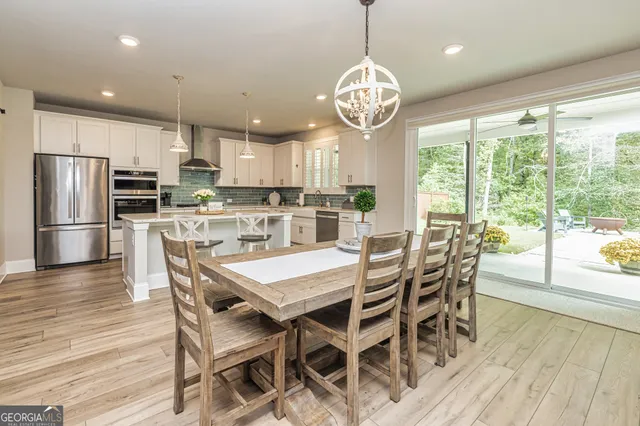 a kitchen with stainless steel appliances granite countertop a kitchen island a stove a table and chairs in it