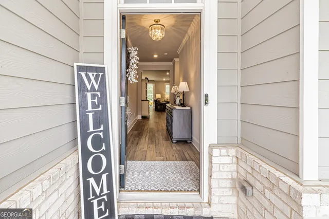 a view of a hallway with wooden floor and a living room