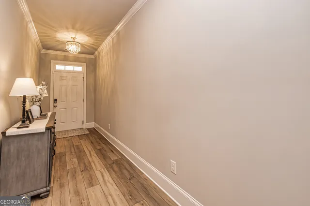 a view of a hallway with wooden floor and a bathroom