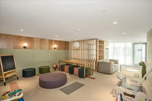 a living room with furniture a flat screen tv and floor to ceiling window