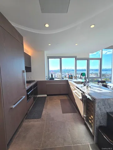 a kitchen with stainless steel appliances kitchen island granite countertop a table chairs sink and cabinets