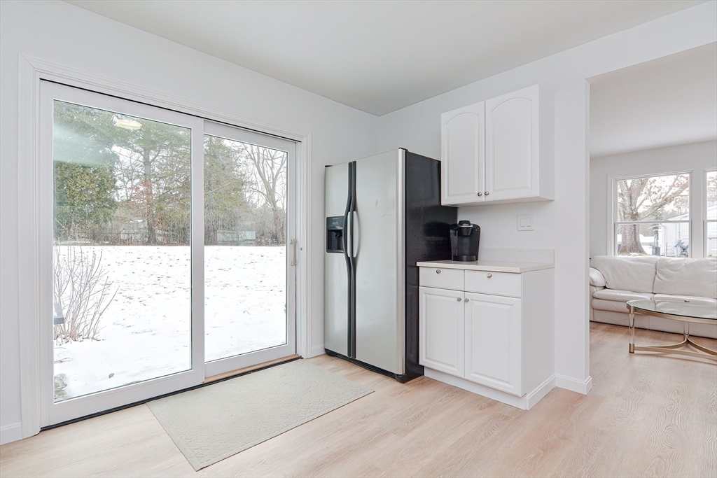 257 Brook Circle Hanover, MA 02339 - Photo 8 of 23 a kitchen with white cabinets and wooden floor