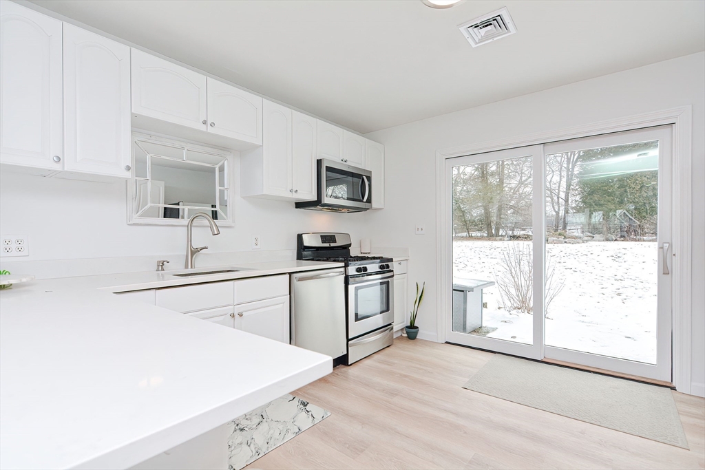 257 Brook Circle Hanover, MA 02339 - Photo 9 of 23 a kitchen with a stove a sink and a window