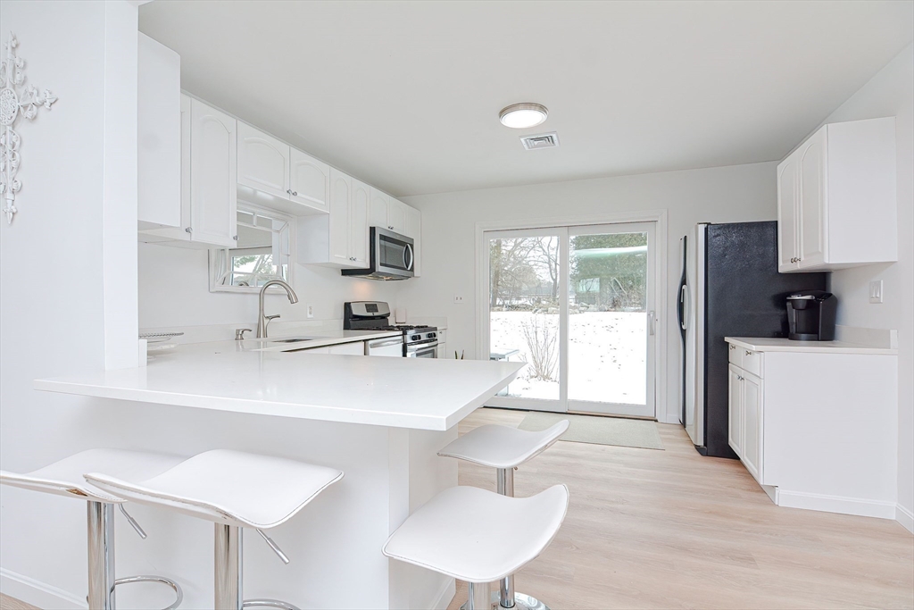 257 Brook Circle Hanover, MA 02339 - Photo 10 of 23 a kitchen with kitchen island a sink table and chairs