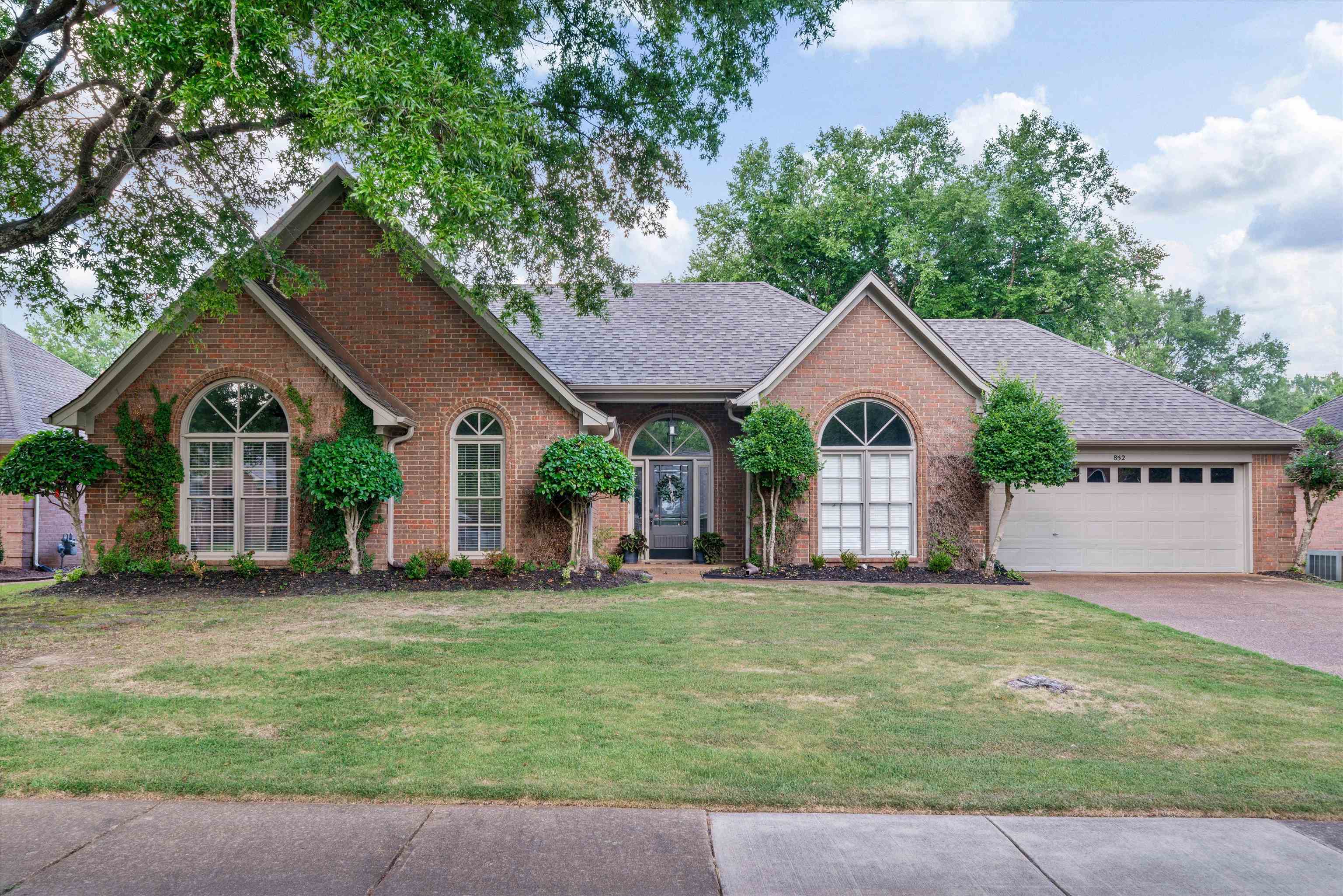 a front view of house with yard and green space