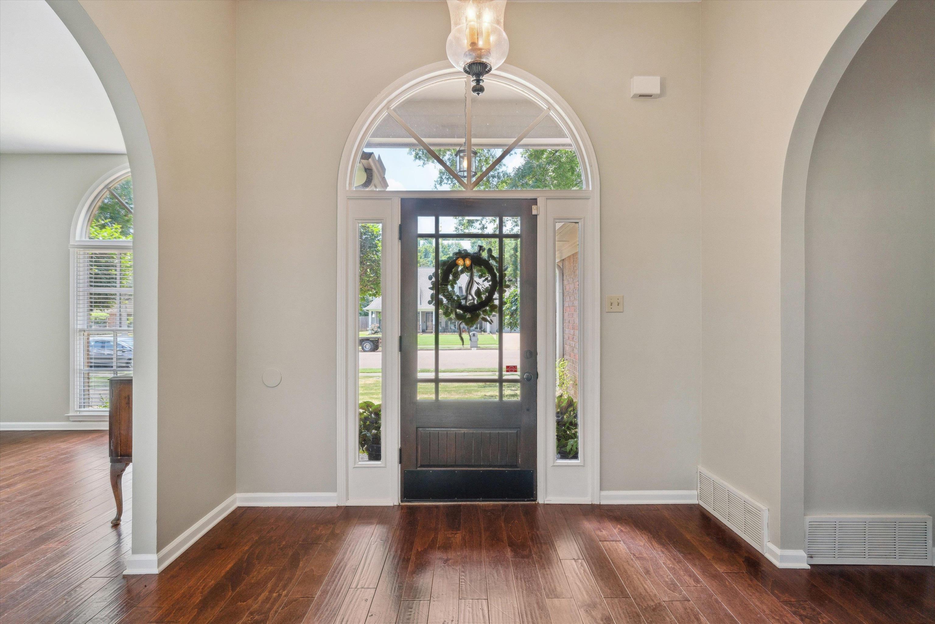 852 Joe Drive Collierville, TN 38017 - Photo 4 of 27 an empty room with wooden floor chandelier and windows