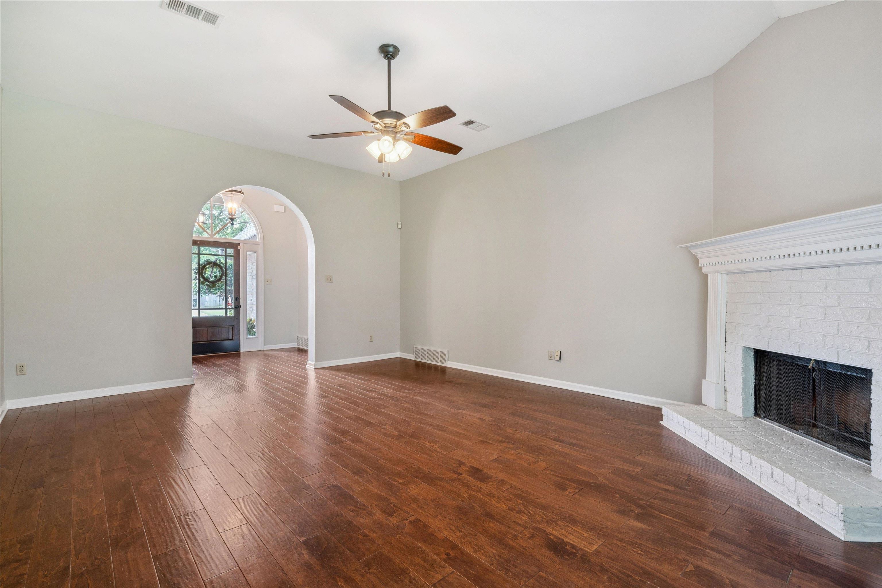 852 Joe Drive Collierville, TN 38017 - Photo 9 of 27 an empty room with wooden floor chandelier fan and windows
