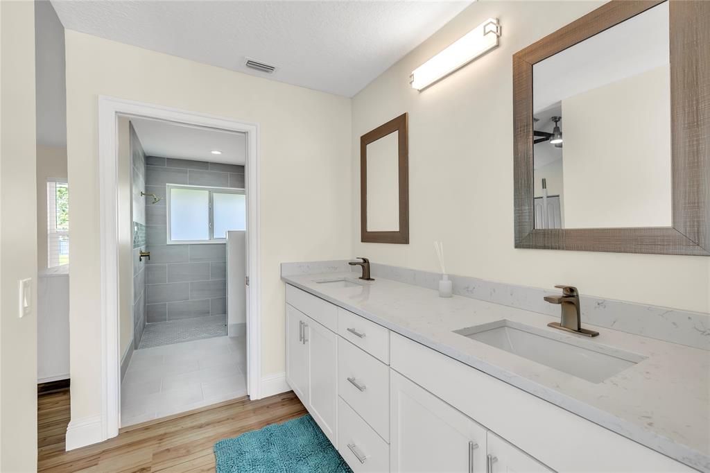 8410 Sawpine Road Delray Beach, FL 33446 - Photo 27 of 37 a bathroom with double sink and a mirror