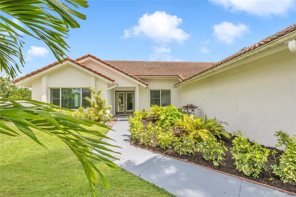 8410 Sawpine Road Delray Beach, FL 33446 - Photo 4 of 37 a front view of a house with garden