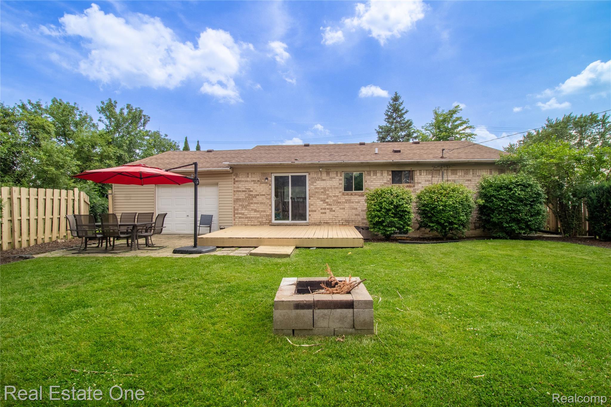 44220 Saltz Road Canton, MI 48187 - Photo 24 of 31 Expansive backyard featuring a manicured lawn, a low-profile wood deck, and a brick veneer exterior