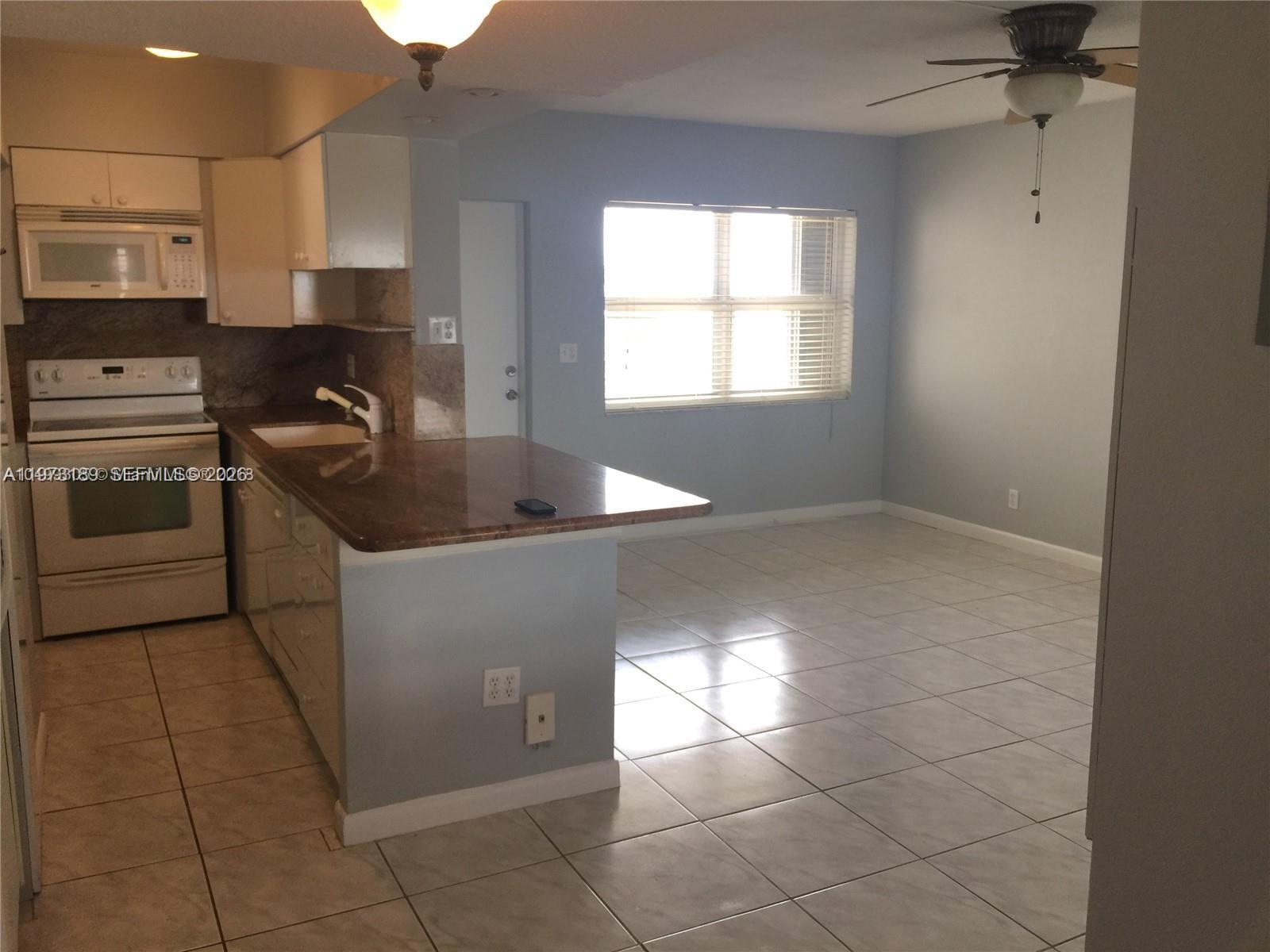 901 South Surf Road, Unit 402 Hollywood, FL 33019 - Photo 19 of 25 a kitchen with stainless steel appliances granite countertop a sink and a stove